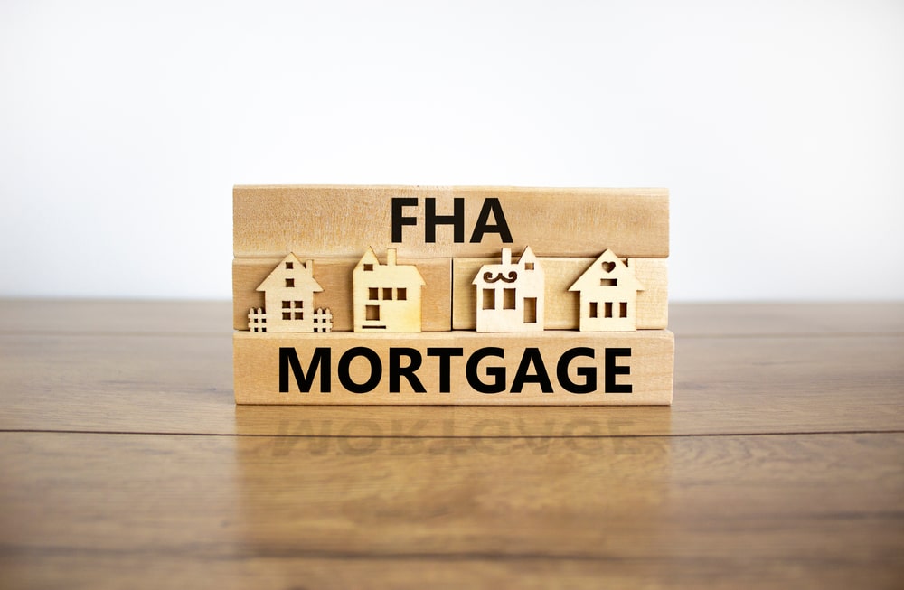 Wooden sign with houses carved into it with captions read FHA Mortgage
